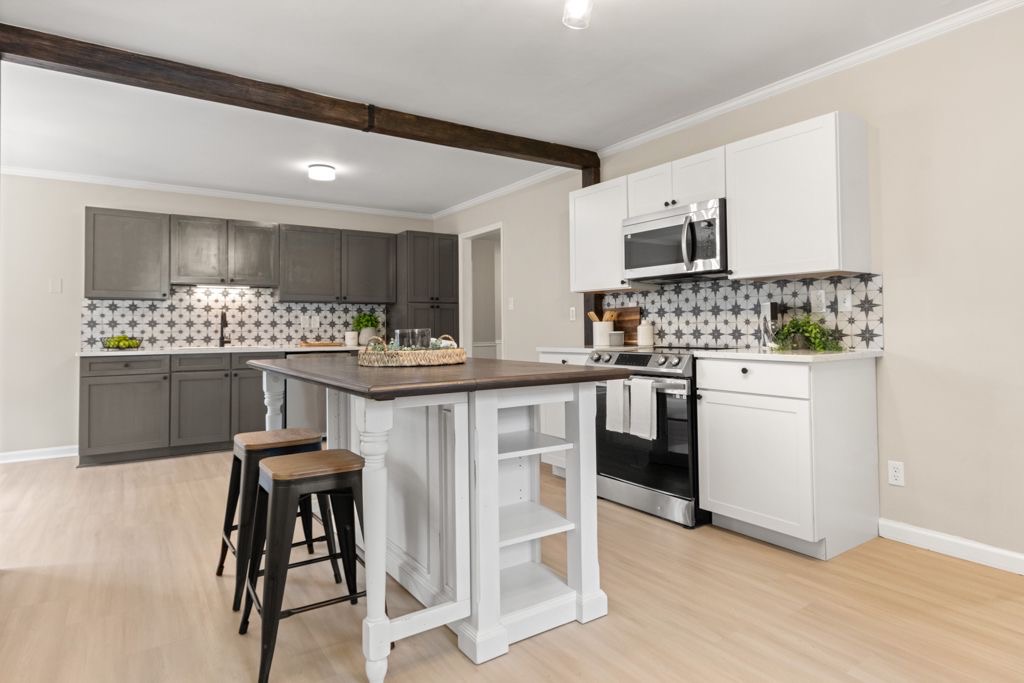 Remodeled kitchen with white and gray cabinets